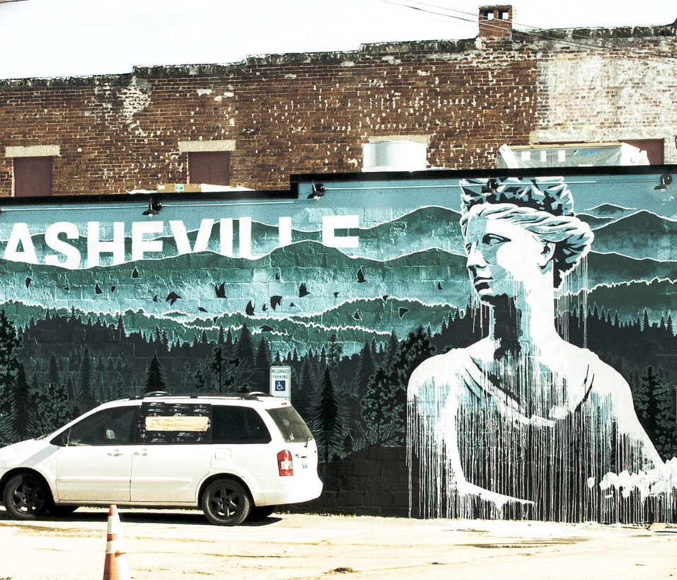 A mural of a woman with a white car in front